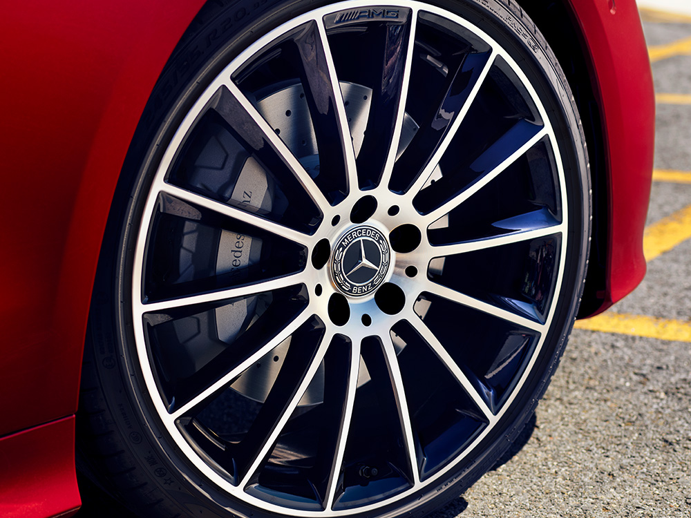 Nahaufnahme einer silbernen Vielspeichenfelge auf einem roten Mercedes-Benz